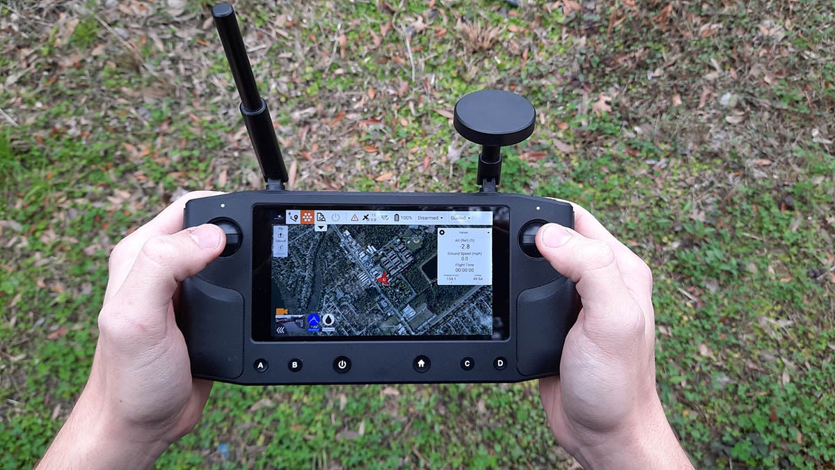 man holding a controller that displays a map on its screen